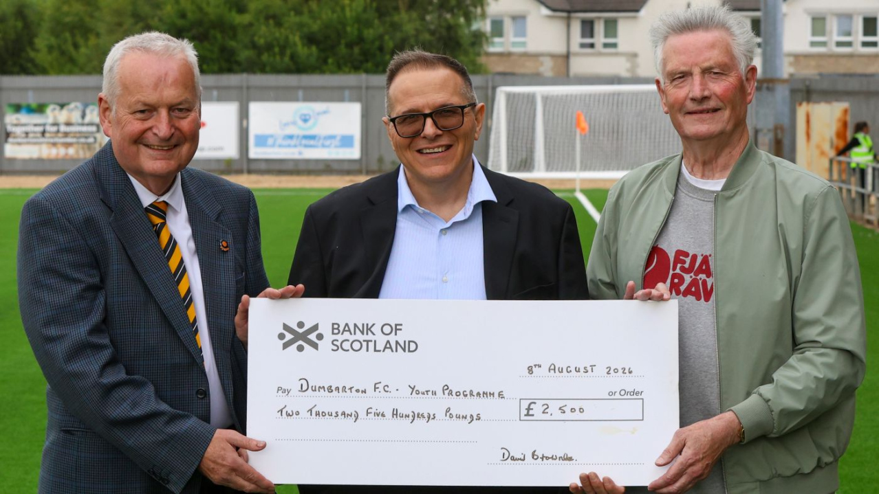 Robert Ryan and David Brownlee of the Sonstrust present Mario Lapointe of Dumbarton FC with a cheque for youth development